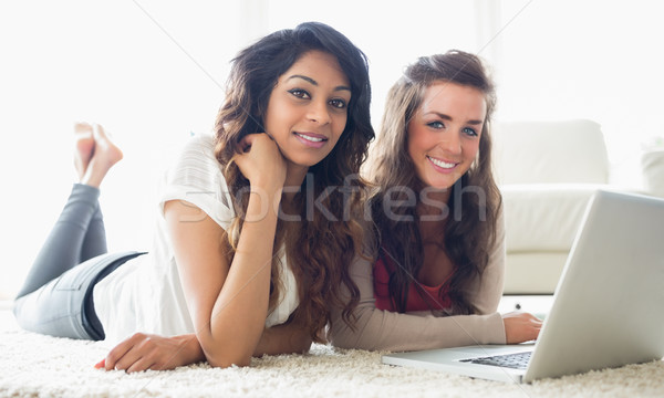 Twee glimlachend vrouwen typen computer vloer Stockfoto © wavebreak_media