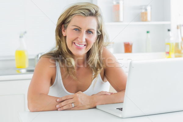 Mosolygó nő ül konyha laptopot használ számítógép nő Stock fotó © wavebreak_media