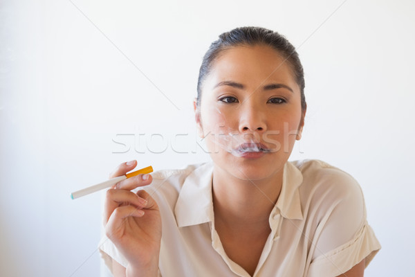 Femme d'affaires fumer électronique cigarette bureau [[stock_photo]] © wavebreak_media