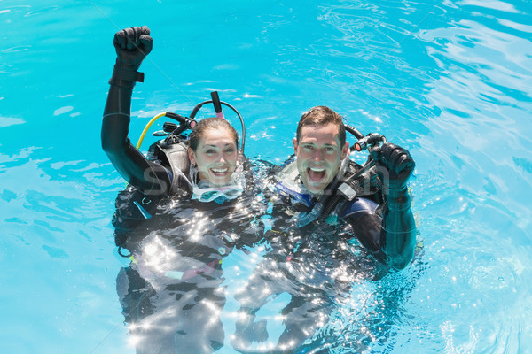 Smiling couple on scuba training in swimming pool looking at cam Stock photo © wavebreak_media