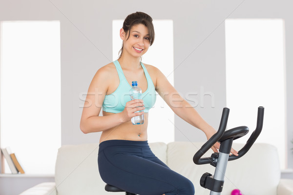 Potrivi bruneta exercita bicicletă acasă Imagine de stoc © wavebreak_media