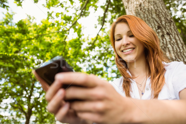 Csinos vörös hajú nő sms üzenetküldés telefon park napos idő Stock fotó © wavebreak_media