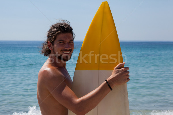 Sorridente surfista prancha de surfe em pé praia costa Foto stock © wavebreak_media