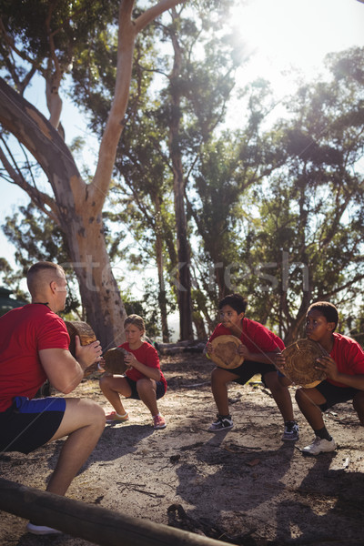 Trainer and kids carrying wooden logs during obstacle course training Stock photo © wavebreak_media