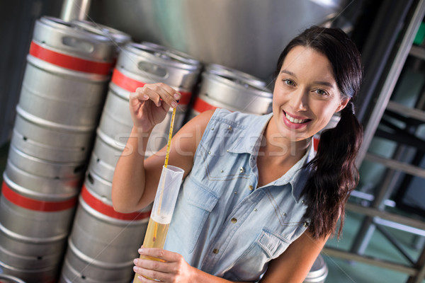 Portrait of female worker examining beer in test tube at factory Stock photo © wavebreak_media