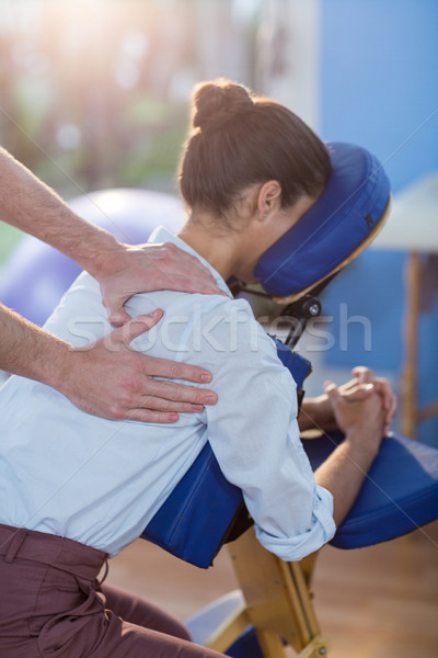 Stock photo: Physiotherapist giving shoulder massage to a female patient