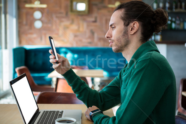 Homme téléphone portable portable table cafétéria ordinateur [[stock_photo]] © wavebreak_media