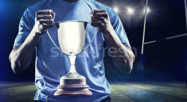 Composite image of mid section of sportsman holding trophy Stock photo © wavebreak_media