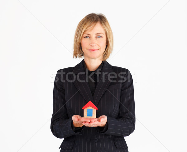 Confident mature businesswoman holding a house against a white background Stock photo © wavebreak_media