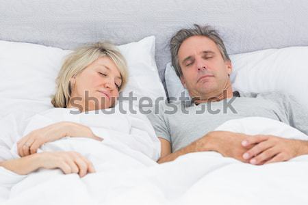 Beautiful couple sleeping on their bed Stock photo © wavebreak_media
