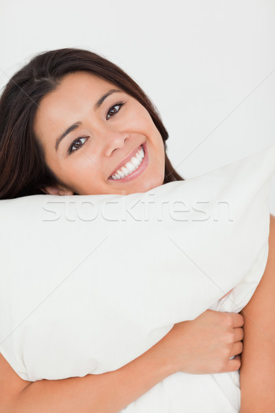 Close Up Of A Cute Woman With Pillow Sitting On Her Bed Looking