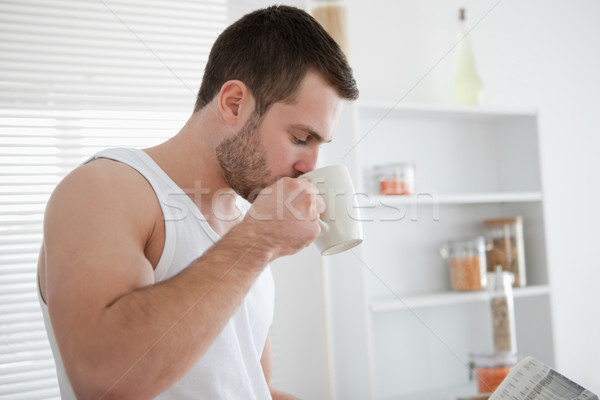 Man drinking coffee while reading the news in his kitchen Stock photo © wavebreak_media