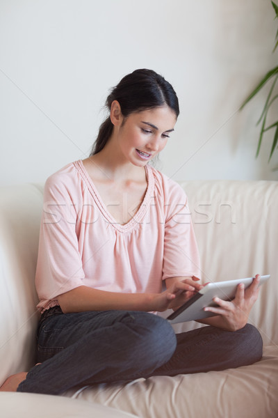 Stock photo: Portrait of a woman using a tablet computer in her living room