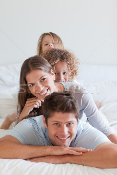 Stock photo: Portrait of a family lying on each other in a bedroom
