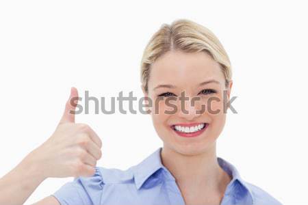 Smiling woman giving thumb up against a white background Stock photo © wavebreak_media