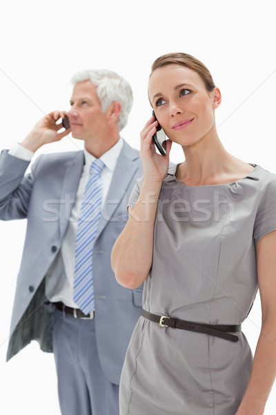 Close-up of a woman making a call with a white hair businessman in background Stock photo © wavebreak_media