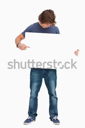 Male student holding and looking a white board against white background Stock photo © wavebreak_media