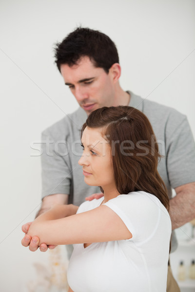 Serious doctor stretching the arm of a patient in a room Stock photo © wavebreak_media