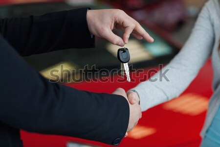 Car keys hold by someone over someone else hand in a car shop Stock photo © wavebreak_media