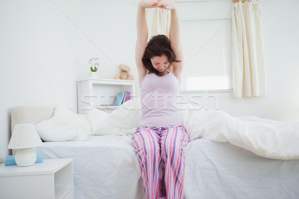 Senny młoda kobieta broni w górę bed Zdjęcia stock © wavebreak_media