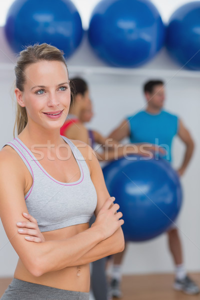 Young Woman With Friends In Background At Fitness Studio Stock Photo C Wavebreak Media Ltd Wavebreak Media Stockfresh