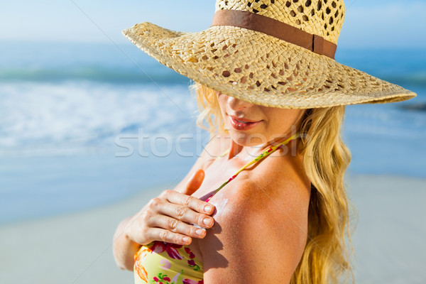 Gorgeous blonde in bikini applying suncream on the beach Stock photo © wavebreak_media