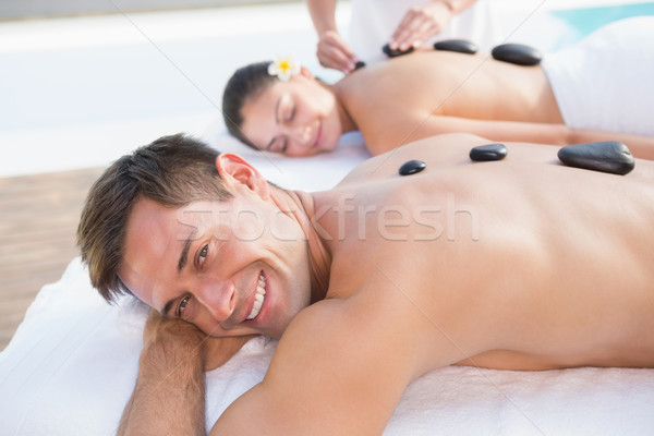 Attractive couple enjoying hot stone massage poolside Stock photo © wavebreak_media