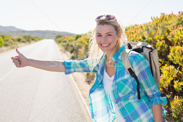 Stock photo: Attractive blonde hitch hiking on rural road