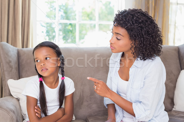 Pretty mother sitting on couch scolding her daughter Stock photo © wavebreak_media