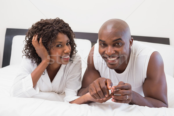Happy couple lying on bed together Stock photo © wavebreak_media
