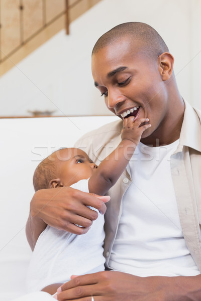 Stock photo: Happy young father spending time with baby on the couch