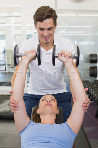 Personal trainer ajutor client ridicare gantere sală de gimnastică Imagine de stoc © wavebreak_media