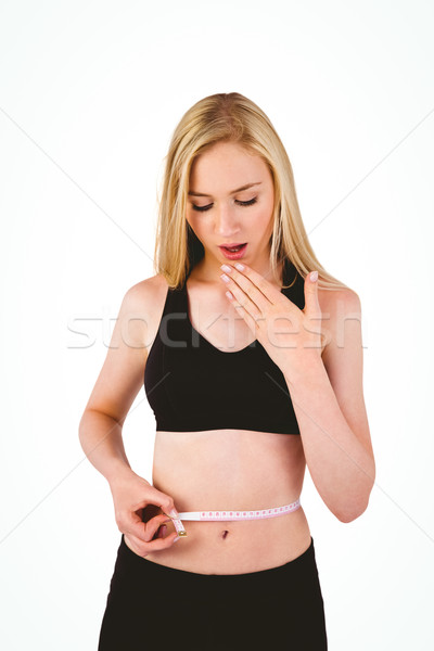 Fit young blonde looking at measuring tape Stock photo © wavebreak_media