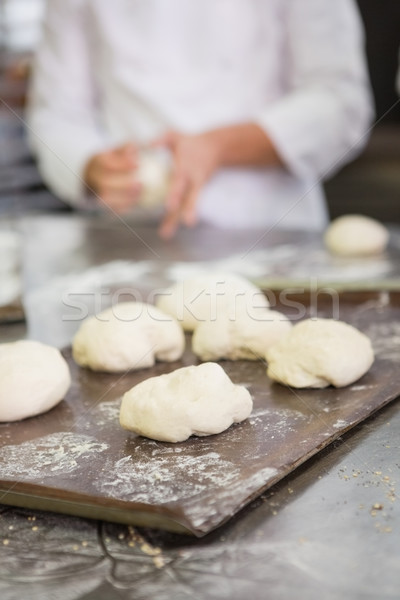 Baker kneading uncooked dough on worktop Stock photo © wavebreak_media