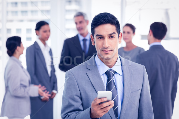 üzletember mobiltelefon kollégák mögött iroda nő Stock fotó © wavebreak_media