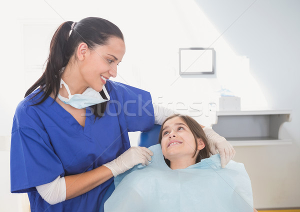 Pediatric dentist putting on her young patient the scrubs Stock photo © wavebreak_media