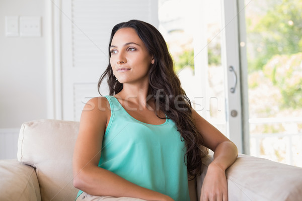 Dość brunetka posiedzenia fotel domu salon Zdjęcia stock © wavebreak_media