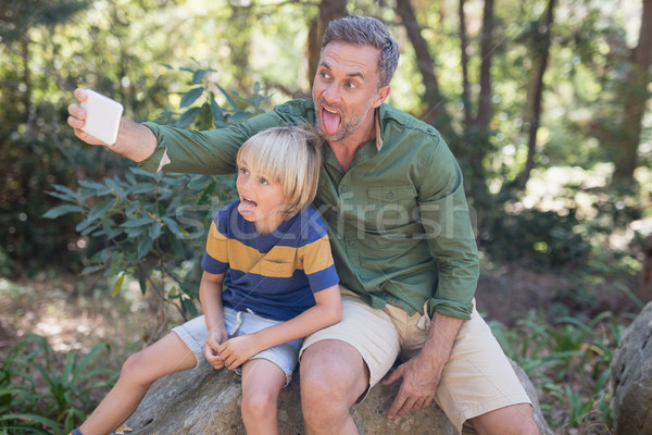 Father and son sticking out tongue while taking selfie in forest Stock photo © wavebreak_media