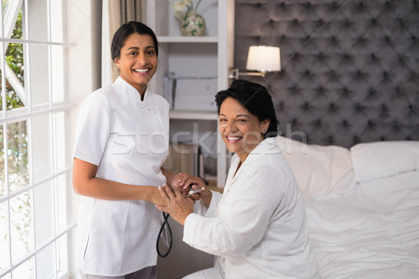 Smiling nurse and female patient at home Stock photo © wavebreak_media