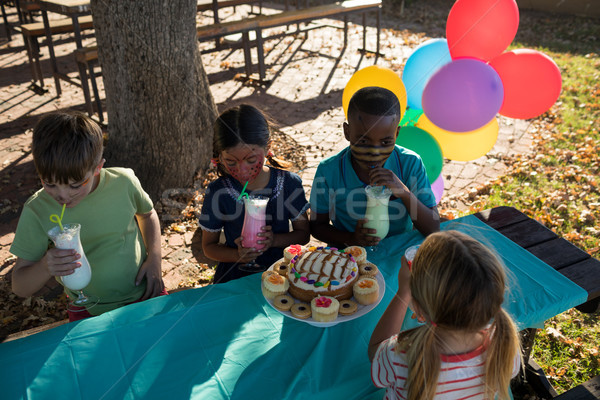 Children enjoying drink while sitting at table in park Stock photo © wavebreak_media