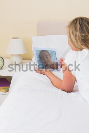 Thoughtful woman having coffee while sitting on sofa against white background Stock photo © wavebreak_media