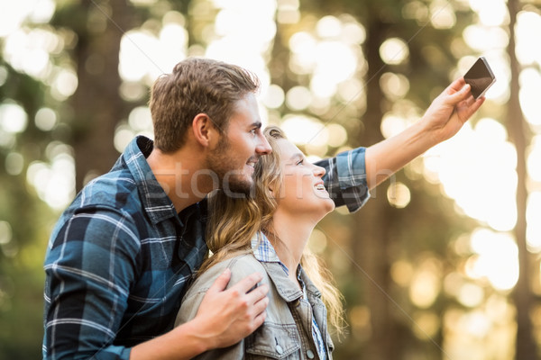 Happy smiling couple embracing and taking selfies Stock photo © wavebreak_media