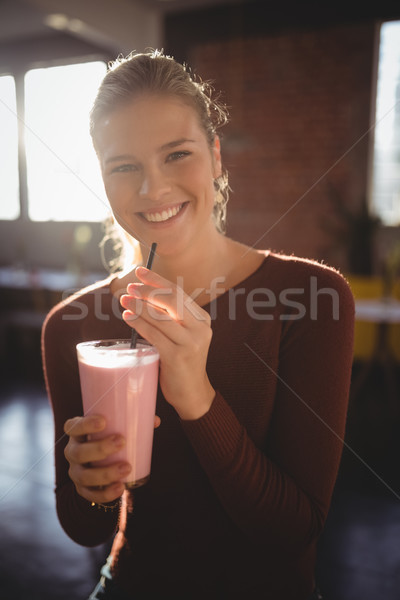 Portrait of smiling young woman with milkshake at cafe Stock photo © wavebreak_media