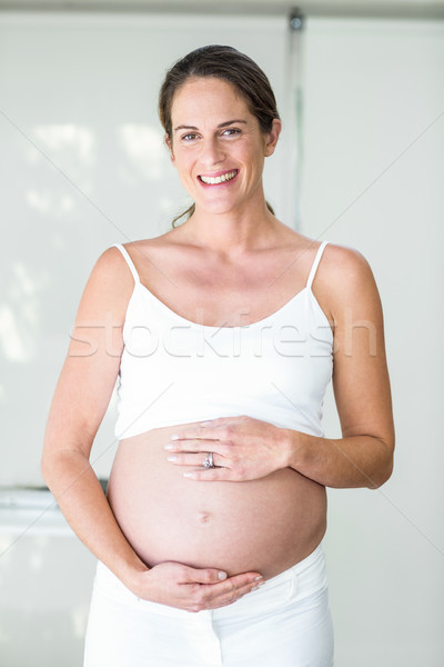 Portrait of happy woman with hands on belly Stock photo © wavebreak_media