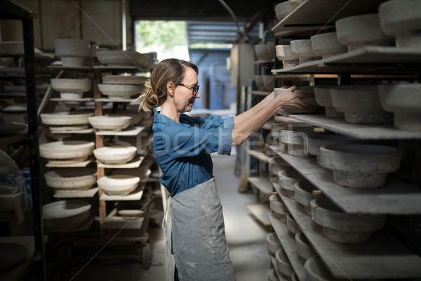 Female potter placing bowl in shelf Stock photo © wavebreak_media