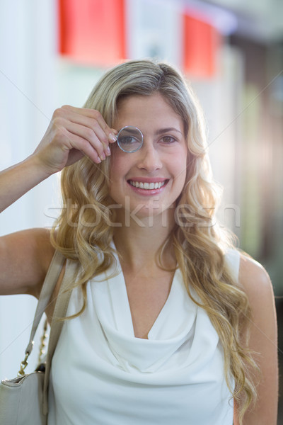 Female customer looking through magnifying glass Stock photo © wavebreak_media