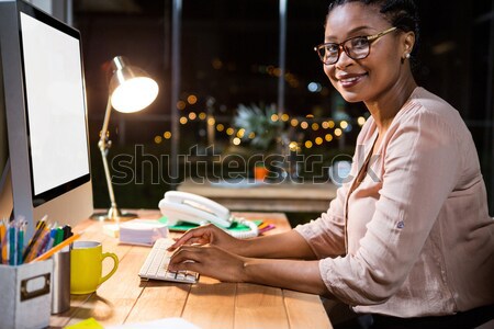 Stock photo: Businesswoman working on computer at her desk