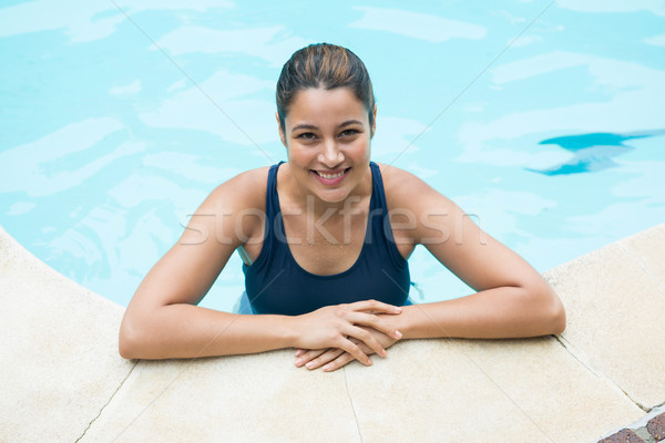 Smiling woman leaning on poolside Stock photo © wavebreak_media