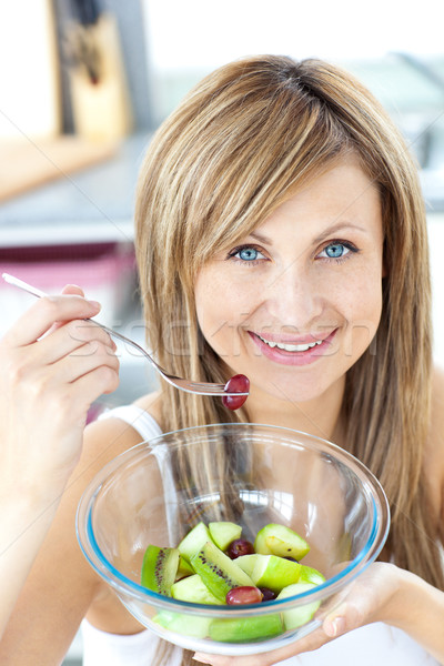 Portrait of a radiant woman eating a fruit salad in the kitchen at home Stock photo © wavebreak_media