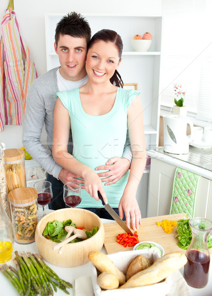 Enamored young couple cutting vegetables in the kitchen at home Stock photo © wavebreak_media